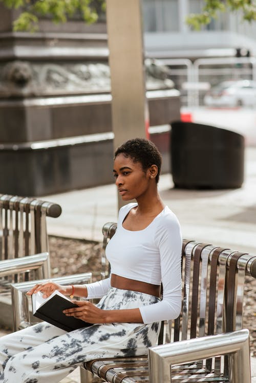 长凳的严肃的黑人妇女与书 · 免费素材图片