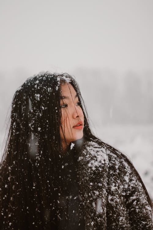 雪在她的衣服上的女人 · 免费素材图片