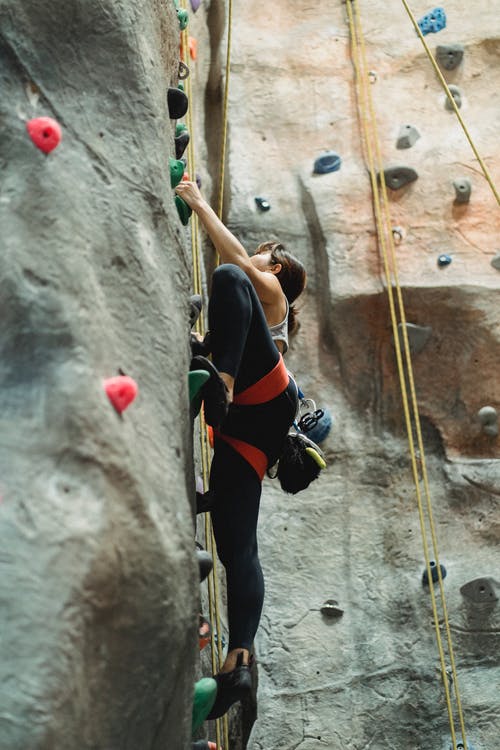 坚强的女人训练在攀岩墙上 · 免费素材图片
