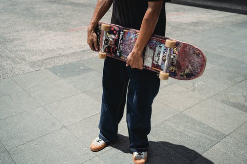 在小镇的人行道上滑板的匿名运动员 · 免费素材图片