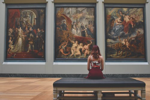 女人坐在奥斯曼帝国在三幅画前 · 免费素材图片