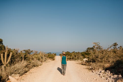 在尘土飞扬的道路上行走的女人 · 免费素材图片
