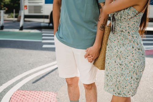 情侣站在人行道上时手牵着手 · 免费素材图片