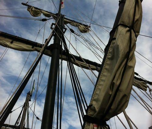多云的天空下船上起皱的帆的低角度摄影 · 免费素材图片