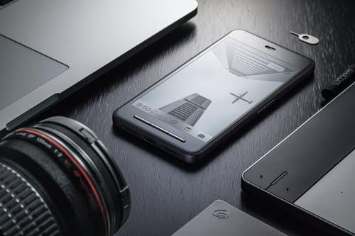 黑色表面上的黑色android智能手机 · 免费素材图片