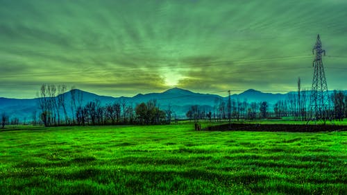 绿草附近的山的剪影摄影 · 免费素材图片