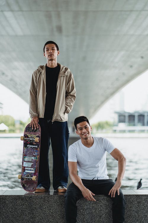 滑板在路堤上的年轻人 · 免费素材图片