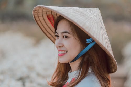 微笑的女人，戴着柳条帽子选择性焦点摄影 · 免费素材图片