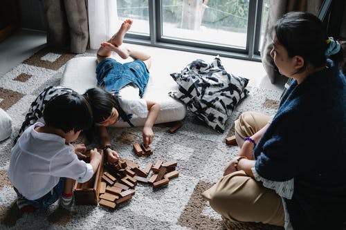 奶奶看着亚洲孩子玩塔式游戏 · 免费素材图片