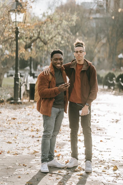 棕色外套的男人和蓝色牛仔牛仔裤站在棕色外套的女人旁边 · 免费素材图片