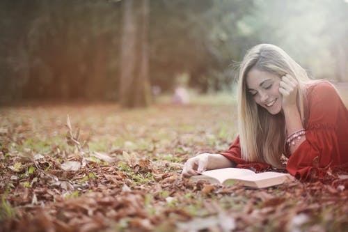 躺在褐色的红裙子的女人干地面上的叶子 · 免费素材图片