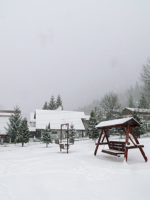 棕色的木凳，在积雪覆盖的地面上 · 免费素材图片