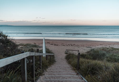 楼梯覆盖着沙子通往宁静的海滩 · 免费素材图片