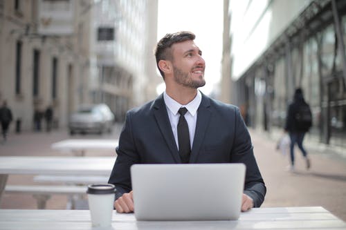 使用macbook的黑色西装外套的男人 · 免费素材图片