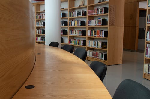 棕色的木桌和黑色的椅子，在图书馆 · 免费素材图片