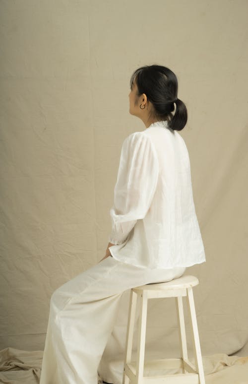 坐在白色的木椅上的白色长袖连衣裙的女人 · 免费素材图片