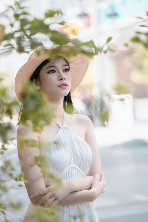白色吊带裙礼服和棕色太阳帽的女人 · 免费素材图片