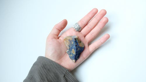 持有蓝色和棕色石头的人 · 免费素材图片