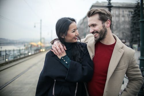 站在黑色外套的女人旁边的棕色外套的男人 · 免费素材图片