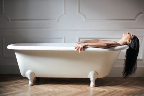 躺在白色的浴缸上的女人 · 免费素材图片