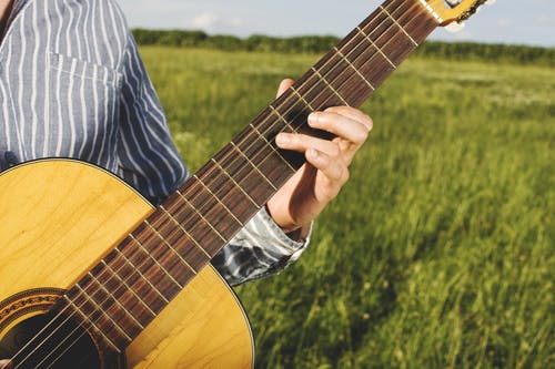 在草地上弹吉他的人 · 免费素材图片