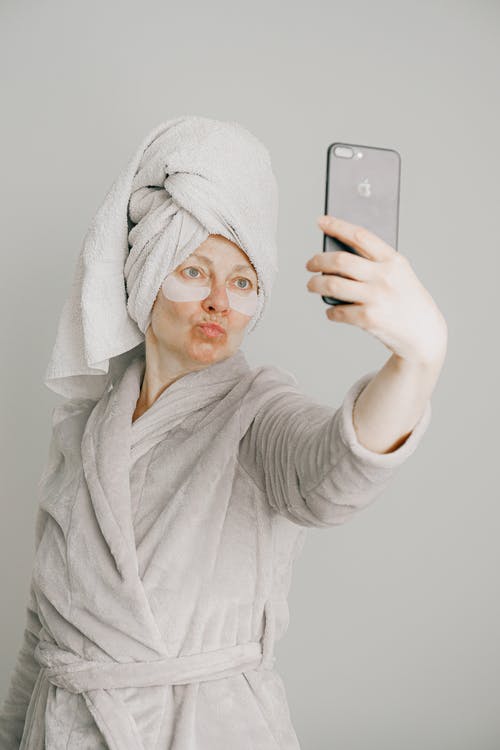 拿着iphone 6的灰色浴袍的女人 · 免费素材图片