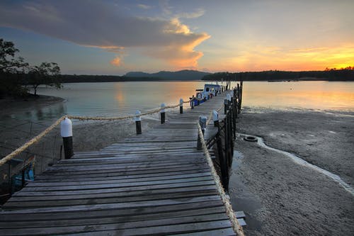 棕色木制码头在海洋附近的岸上 · 免费素材图片