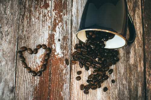 黑色陶瓷咖啡杯和咖啡豆 · 免费素材图片