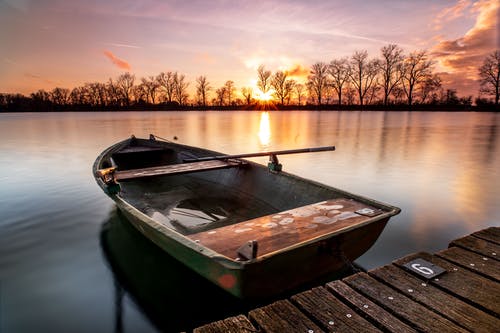 日落期间在码头上的棕色木船 · 免费素材图片