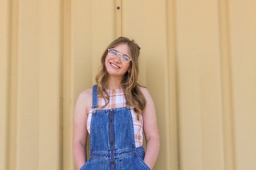 蓝色牛仔布粗斜纹棉布和棕色框架眼镜摆在微笑的女人的照片 · 免费素材图片
