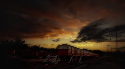 在日落期间采取的红色和白色火车 · 免费素材图片