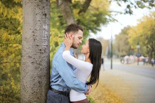 拥抱夫妇站在树旁看着对方的选择性焦点照片 · 免费素材图片