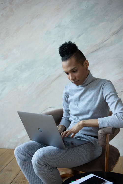 使用macbook的灰色长袖衬衫的男人 · 免费素材图片