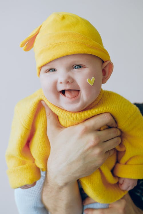 婴儿的黄色针织帽和黄色的针织毛衣 · 免费素材图片