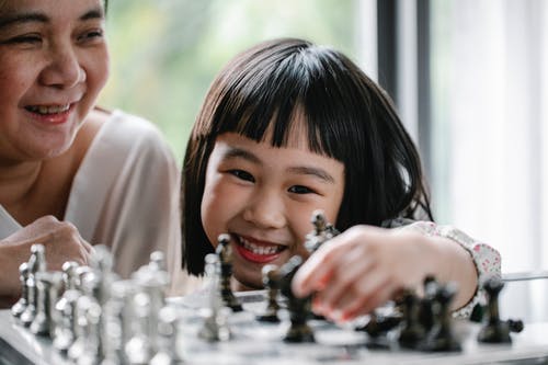 与下棋的祖母快乐的亚洲女孩 · 免费素材图片