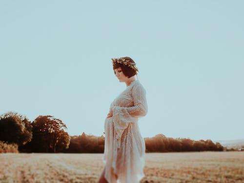 年轻孕妇在草地上 · 免费素材图片