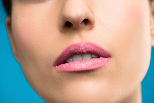 女人用粉红色唇膏的特写照片 · 免费素材图片