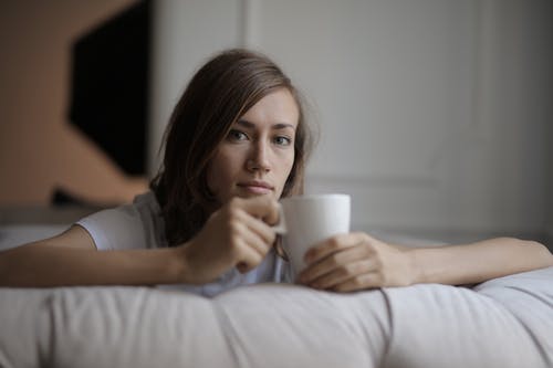 拿着白色陶瓷杯子的白衬衫的女人 · 免费素材图片