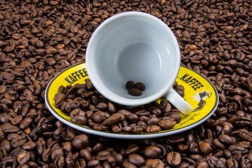 黄板上的白色陶瓷杯咖啡豆 · 免费素材图片