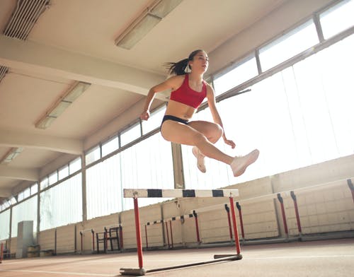 一个女人的照片跳上障碍 · 免费素材图片