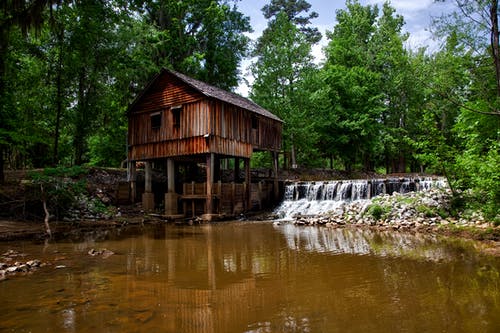 棕色木房子在河边森林景观摄影 · 免费素材图片