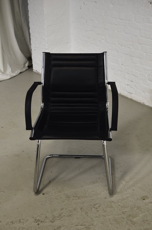 白墙旁的黑色和银色椅子 · 免费素材图片