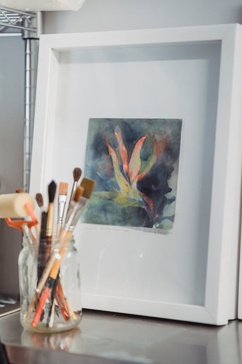 艺术材料放置在彩色艺术品附近 · 免费素材图片