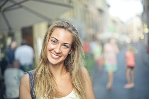 白色背心的微笑妇女的选择性焦点肖像照片 · 免费素材图片