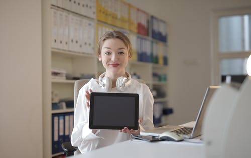 女人抱着一台平板电脑 · 免费素材图片