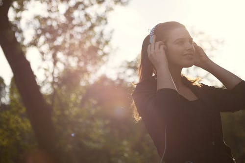 黑色的长袖衬衫，一边听音乐的女人 · 免费素材图片