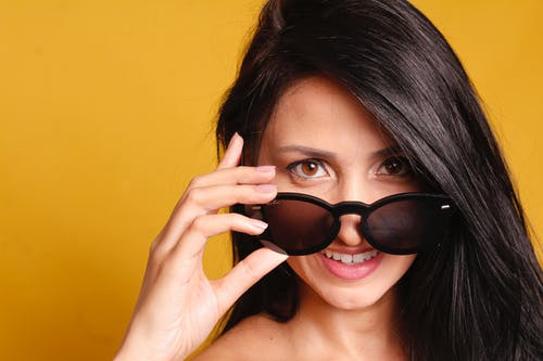 微笑的女士戴着黑色太阳镜 · 免费素材图片