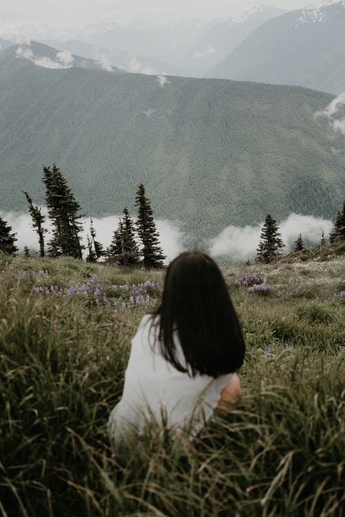 不可识别的女人在山上的草 · 免费素材图片