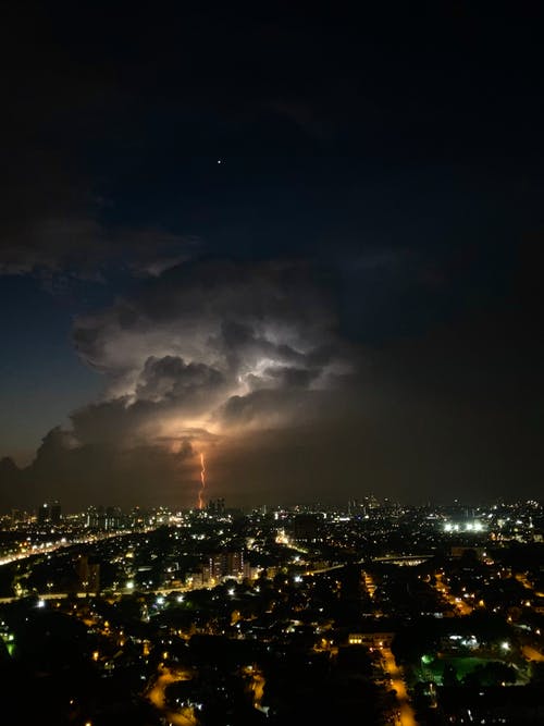 夜晚的乌云下的高层建筑的城市 · 免费素材图片