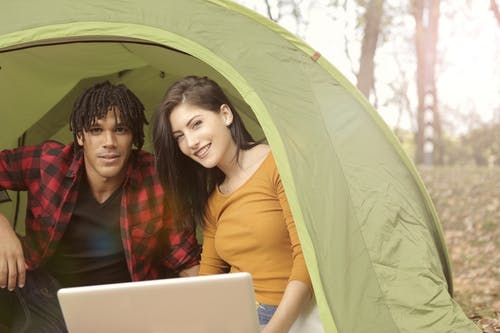 一对夫妇坐在露营帐篷内 · 免费素材图片